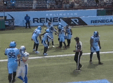 a group of football players on a field in front of a sign that says arlington renegade