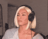 a woman with blonde hair is wearing headphones and making a face
