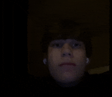 a close up of a person 's face with ear buds on
