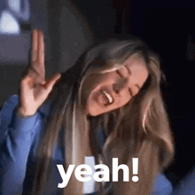 a woman with long blonde hair is making a peace sign and the word yeah is above her