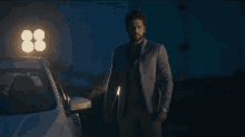 a man in a suit is standing in front of a car with the number 88 on it