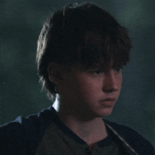 a close up of a young boy 's face with a dark background