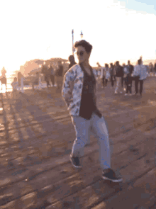 a man in a floral jacket is walking on a pier