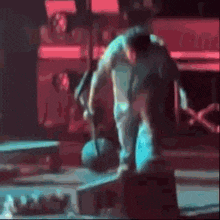 a man is doing a trick on a skateboard while holding a ball .