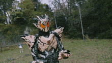 a man in a white shirt is standing in a field with a mask on
