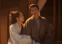a man and a woman are looking at each other in a room .
