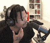 a man wearing headphones is sitting in front of a microphone