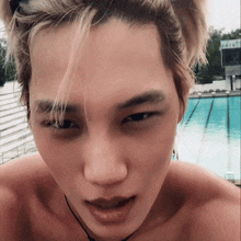 a close up of a man 's face in front of a pool