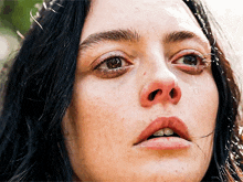 a close up of a woman 's face with tears coming out of her eyes