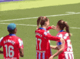 a soccer player with the number 17 on her back is hugging another player
