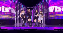 a group of women are dancing on a stage in front of a large screen that says secret number .