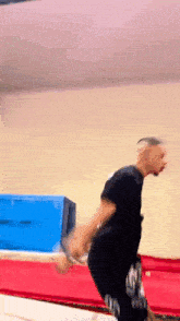 a man is jumping on a trampoline with a box in the background
