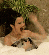 a woman is taking a bath in a tub with her mouth wide open