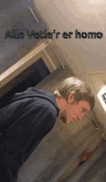 a man standing in a hallway with the words alle vette 'r er homo