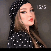 a woman wearing a black and white polka dot head scarf and earrings