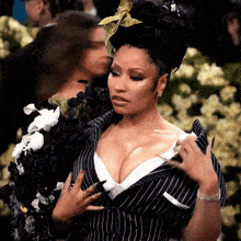 a woman in a black and white striped suit holds her breast