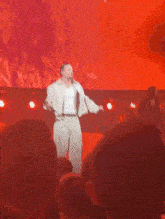 a man singing into a microphone in front of a crowd of people