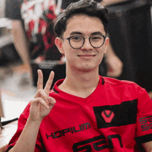a man wearing glasses and a red shirt that says hopium