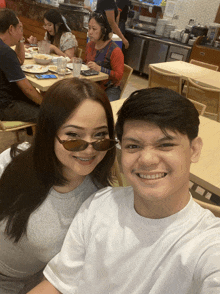 a man and a woman are posing for a photo in a restaurant