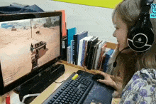 a woman wearing headphones is playing a game on a computer