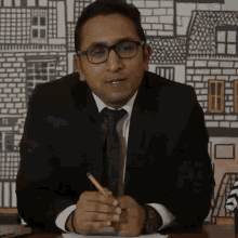 a man in a suit and tie holds a pencil in his hand
