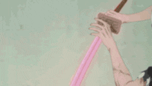 a close up of a person 's hand with a pink light coming from it