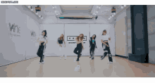 a group of women are dancing in front of a sign that says wine entertainment