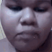 a close up of a woman 's face with a piercing in her nose .