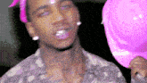 a man with a pink bandana on his head is holding a pink hard hat .