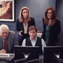 a group of people are sitting in front of computer monitors and a sign that says intrageist