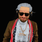 a man wearing a wig and sunglasses has a necklace that says bye on it