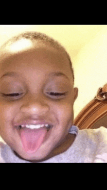 a young boy making a funny face with his tongue sticking out