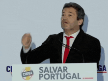 a man stands at a podium with a sign that says salvar portugal on it