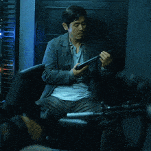a man sitting in a chair holding a gun and looking up