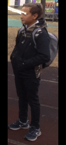 a boy with a backpack is standing in front of a sign that says " hmru "