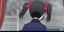 a girl with pigtails is sitting in front of a computer .