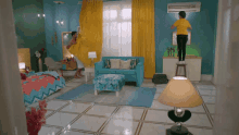 a man in a yellow shirt is hanging curtains in a living room