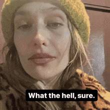 a woman wearing a yellow beanie and a leopard print coat says what the hell sure