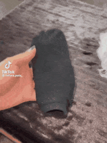 a person is holding a black sock in their hand with tiktok written on it