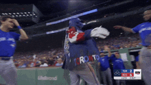 a toronto blue jays baseball player is being hugged by a fan