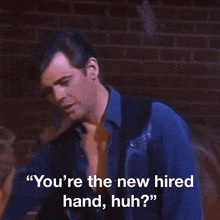 a man without a shirt is talking to another man and says " you 're the new hired hand huh "