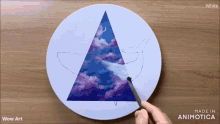 a person is painting a whale in a triangle on a plate with the words wow art on the bottom