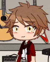 a boy with a scarf around his neck is standing in front of guitars