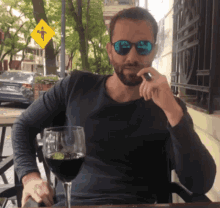 a man sitting at a table with a glass of wine