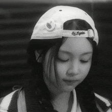 a woman wearing a los angeles hat looks down