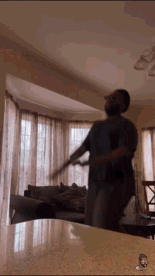 a man is dancing in a living room with a cartoon of a man on the counter