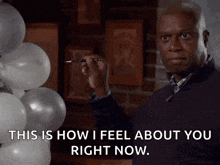 a man is holding a brush in front of balloons and says " this is how i feel about you right now "