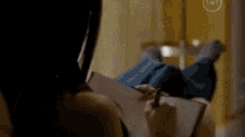 a woman is laying on her stomach writing in a notebook .
