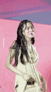a woman in a white dress is dancing in front of a pink background with the name lilyrose39 on the bottom