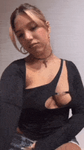 a woman is wearing a choker and a black top with a cut out in the chest .